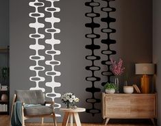 a chair and table in front of a wall with black and white designs on it