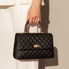 Inspired by aristocratic fashion, this Black Quilted Chainstrap Top Handle Bag radiates elite exclusivity. Choose timeless fashion with this vintage quilted chain strap bag that perfectly goes with your formal dresses, black stilettos, and delicate gold jewelry. Add this Black Quilted Chainstrap Top Handle Bag to your most coveted collection. Luxurious quilted leather exterior Classic leather top handles with detachable black and gold leather chain strap Easily converts from a shoulder bag to a handbag Features one main compartment, one zippered compartment, one internal zippered pocket, & 2 phone compartments Designer Quilted Top Handle Bag, Formal Quilted Top Handle Bag, Luxury Quilted Flap Bag With Top Handle, Timeless Quilted Black Shoulder Bag, Black Quilted Top Handle Bag, Delicate Gold Jewelry, Chain Strap Bag, Black Stilettos, Black Quilt