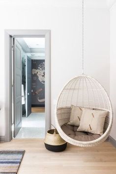 a living room with a hanging chair and pillows