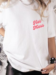 Hot mess- but make it cute. Choose from 6 colors with our Hot Mess graphic tee, printed on high quality Comfort Colors.  .: The Comfort Colors 1717 tee is made with medium fabric (6.1 oz/yd² (206.8 g/m consisting of high quality, 100% ring-spun US cotton for long-lasting comfort. .: The relaxed fit keeps the wearer comfy in both casual and semi-formal settings while the crew neckline delivers that classic, neat style which makes it perfect for accessorizing.  .: The pre-shrunk fabric ensures a consistently great fit. Check all available sizes in our Comfort Colors 1717 size chart.  .: All Comfort Colors 1717 shirts feature pre-shrunk cotton for size retention and a signature sewn-in twill label. .: Made using 100% US cotton that is ethically grown and harvested. Gildan is also a proud memb Red T-shirt With Funny Text For Summer, Funny Pink T-shirt With Text Print, Pink Funny Text T-shirt For Summer, Pre-shrunk White Print Crew Neck T-shirt, Trendy Pre-shrunk Cotton T-shirt, Cotton Crew Neck T-shirt With Text Print, Trendy Pink T-shirt With Funny Text, Cotton Crew Neck T-shirt With Letter Print, Cute Short Sleeve T-shirt With Screen Print