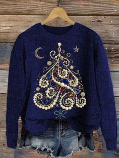 a blue sweater with an embroidered christmas tree on the front, and pearls in the back