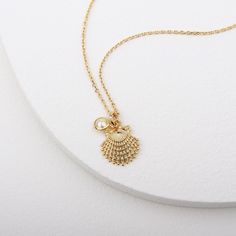 Gold clam shell pendant with tiny pearls inspired by the beautiful ocean world Clams symbolize luck, and give off gentle healing energies, which help in balancing and harmonizing your aura. Please keep the necklace dry and take care in stock after used. Soft and simple. great for gift, everyday or special occasion. Material : Brass, Simulated Pearl Pendant : 13mm x 16mm Pearl : 5mm Shell-shaped Charm Necklaces Made Of Shell As Gift, Dainty Shell Necklaces Perfect As Gifts, Shell Pendant Jewelry With Pearl Charm, Ocean-inspired Shell Charm Necklace With Lobster Clasp, Ocean-inspired Shell Necklace With Lobster Clasp For Gift, Ocean-inspired Pearl Pendant Necklaces As Gifts, Pearl Pendant Shell As Gift, Spiritual Gold Shell-shaped Jewelry, Ocean-inspired Shell-shaped Pearl Pendant Jewelry