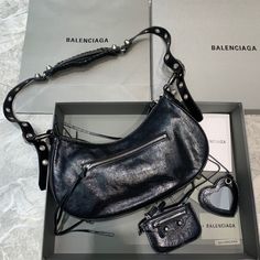 Balenciaga Le Cagole XS Shoulder Bag In Black, For Women, Women’s Bags 13in/33cm Rep 1:1 Size:  33 x 16 x 8.4 cm /13 x 6.3 x 3.3 inches (Lenght x Height x Width) Shoulder bag Adjustable shoulder strap Braided shoulder pad Zipped closure with knotted puller 1 removable zipped pouch 1 removable heart mirror Includes dust bag. This product is of the best quality. Heart Mirror, Balenciaga Bag, New Handbags, Satchel Bags, Fashion Handbags, Shoulder Pads, Designing Women, Contact Us, Wellness Design