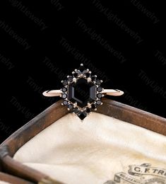 a black diamond ring sitting on top of a wooden box