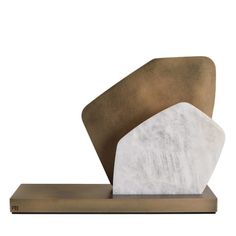 two white and brown sculptures sitting on top of a wooden stand with metal base, one in the shape of a hexagonal object