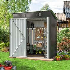 a garden shed with its doors open and gardening tools in the storage area next to it