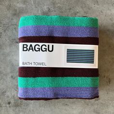 the bath towel is purple, green and blue with a tag on it that says bagu