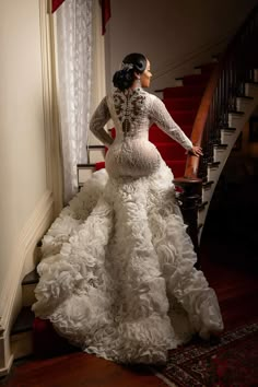 a woman in a wedding dress standing on the stairs