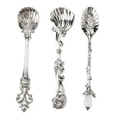 three silver spoons with designs on them and one has a flower design in the middle