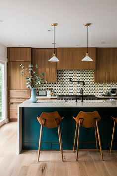 two wooden chairs sitting in front of a kitchen island