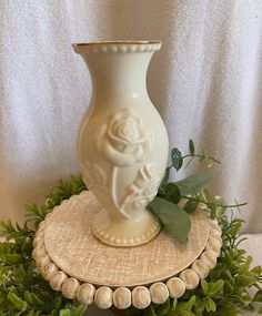 a white vase sitting on top of a wooden stand