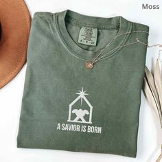 Feiern Sie die wahre Bedeutung von Weihnachten mit diesem elegant gestickten christlichen Hemd mit einem einfachen, aber kraftvollen Krippendesign. Mit dem Satz „A Saviour is Born" und dem Bild der Krippe unter dem Leitstern dient dieses Shirt als schöne Erinnerung an die Geburt Christi. Hergestellt aus einem bequemen, hochwertigen Stoff, eignet es sich sowohl für Freizeitkleidung als auch für festliche Zusammenkünfte. Erhältlich in vielseitigen Farboptionen, ist dieses Design ein sinnvolles Ges The Birth Of Christ, True Meaning Of Christmas, Christmas Tshirt, Religious Christmas, Christian Christmas, Christmas Nativity, Christmas Men, Christian Shirts, Christmas Shirt