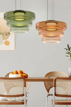 three hanging lights above a table with fruit on it