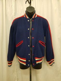 Vintage REVERSIBLE 1960s Buxton Trophy Jacket Navy Blue, Red, & White Patriotic Letterman Jacket Sports Coat High School Sports Varsity.  Jacket has a 7 snap front closure, elastic waist, and 2 side front pockets. Jacket is in great vintage condition (one small imperfection on the back left shoulder of the tan side of the jacket)! Coat Measurements: Shoulder to shoulder 16, neck to bottom hem 25, sleeve shoulder to cuff 24, sleeve pit to cuff 18, chest 42, waist 34 stretch to 42 inches when snap High School Sport, Trophy Jacket, High School Sports, Sports Coat, Letterman Jacket, School Sports, Sport Coat, Shoulder Sleeve, Red White