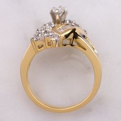 a yellow gold ring with two diamonds on the top and side stones in the middle