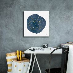 a white desk with a black and gold chair next to it on a gray wall