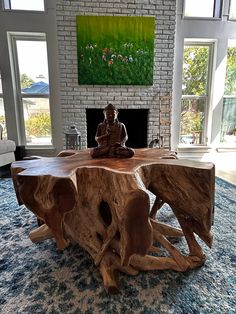 a large wooden table sitting on top of a blue rug in front of a fireplace