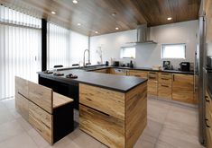 a large kitchen with wooden cabinets and black counter tops, along with a stainless steel refrigerator