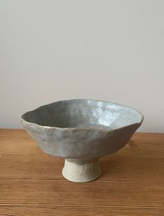 a white bowl sitting on top of a wooden table