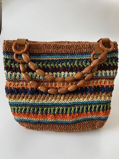 a multicolored purse sitting on top of a white table