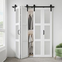 a green chair sitting in front of a white closet with sliding doors and clothes on hangers