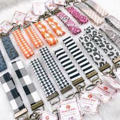 a collection of key chains with different patterns and colors on them sitting on a white furnishing