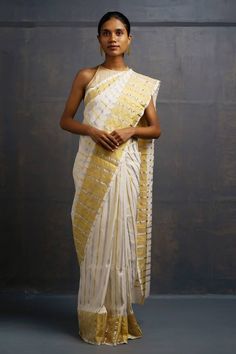 Ivory handwoven saree kasavu featuring stripe pattern all over with golden border. Comes with unstitched blouse piece. - Aza Fashions White Handloom Pre-draped Saree, White Cotton Silk Pre-draped Saree For Festivals, Elegant White Pre-draped Saree For Festivals, White Cotton Silk Pre-draped Saree With Zari Work, White Silk Pre-draped Saree With Zari Work, White Pre-draped Saree For Designer Wear, Elegant White Pre-draped Saree With Pallu, White Chanderi Pre-draped Saree With Zari Work, White Cutdana Pre-draped Saree For Puja