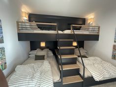 two bunk beds in a room with paintings on the wall and stairs leading up to them