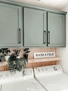 a washer and dryer in a laundry room with green cabinets above the washer