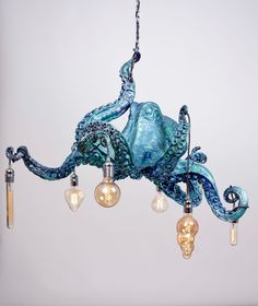 an octopus chandelier hanging from a chain with light bulbs in it's mouth