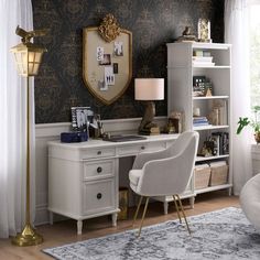 a white desk with a chair and lamp in front of a mirror on the wall