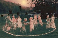 a group of women dressed in costume standing around a circle with cats on it's back