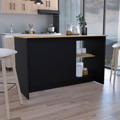 a kitchen with wooden flooring and black counter top next to a window overlooking the ocean