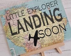 a wooden sign that says little explorer landing soon on it with an airplane in the middle