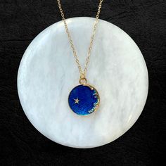 Gold-plated adjustable chain with dark blue ceramic night sky pendant. Available on a single chain as well as a double layered chain. Blue Moon Charm Pendant Necklace, Blue Moon Phase Round Pendant Necklace, Blue Celestial Necklace With Moon Charm, Celestial Blue Jewelry With Moon Charm, Blue Celestial Pendant Jewelry, Blue Celestial Round Jewelry, Celestial Blue Round Jewelry, Blue Moon Phase Round Pendant Jewelry, Celestial Blue Necklaces