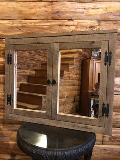 a wooden cabinet with two mirrors on it