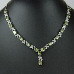 "WHITE GOLD FINISH Created Diamond Peridot \"Love and Kisses\" Necklace, Part of the Love and Kisses Collection This stunning green necklace is hand finished with beautiful peridot stones and created diamonds. It's a sophisticated touch to any look making you look elegant and graceful. Peridot, the bright green colour of nature, is associated with harmony, good health, restful sleep, and peacefulness. Known as the stone of compassion, peridot calms anger by giving renewal to all things. When set in gold, this gem was said to protect the wearer from nightmares. Beautifully designed to make a wonderful moment into a truly amazing moment and a special gift for that someone special. You are already beautiful; this piece will simply adorn your own inner beauty and reflect your decorated eleganc Luxury Elegant Peridot Jewelry, Luxury Peridot Necklace, Peridot Jewelry Set, Peridot Jewelry Necklaces, Luxury Peridot Jewelry For Formal Occasions, Luxury Peridot Jewelry For Gifts, Green Hallmarked Diamond Necklace For Wedding, Hallmarked Green Diamond Necklace For Wedding, Luxury Hallmarked Peridot Jewelry