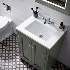 a white sink sitting next to a toilet in a bathroom on top of a tiled floor