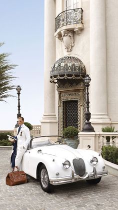 a man standing next to a white sports car