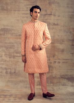 Featuring this peach colour sherwani in banarasi silk. The cuffs and Collar of sherwani are embellished with hand-embroidery, It can be paired with churidaar as well. Perfect fit for any wedding function. Brand: Panache Haute Couture Availability: Online and In-store Delivery Time: 4-6 Weeks Fabric: Sherwani - Banarasi Silk and Bottom (Churidaar) - Lycra Satin or Trouser - Raw Silk Customisation: For more colour options please contact our team through WhatsApp+61470219564 Disclaimer: The model i Peach Embroidered Kurta For Wedding, Orange Zari Work Sherwani For Wedding, Orange Sherwani With Zari Work For Wedding, Orange Wedding Sherwani With Zari Work, Wedding Orange Sherwani With Zari Work, Orange Sherwani For Wedding Eid Festival, Orange Sherwani For Wedding And Eid, Orange Sherwani For Wedding At Eid, Peach Long Sleeve Kurta For Wedding