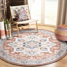 a large round rug with an ornate design on the floor in front of a window