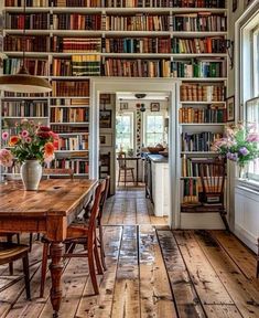 a room filled with lots of books on top of a book shelf next to a window