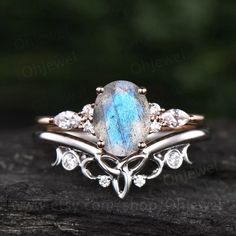 a ring with a blue stone surrounded by white diamonds on top of a piece of wood