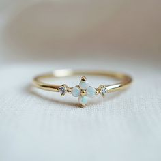 This dainty Forget Me Not ring features four natural Australian opal hugged between two natural diamonds. Set on a polished dainty band. A beautiful ring to wear on your finger to remind you of the beauty of life. Crafted in 14K solid gold in our NYC studio. Materials: - 14K gold - Natural Australian opals and blue sapphires - 1.2mm ring band ** This item is specially made for you. Please allow 1-2 week lead time. Shipping: Domestic: Ship via USPS priority mail International: $15 for internation Delicate Opal Promise Ring, Delicate 14k Gold Opal Ring, Delicate Yellow Gold Opal Ring, Dainty Opal Birthstone Ring, Forget Me Not Jewelry, Forget Me Not Ring, Opal And Sapphire Ring, Graduation Rings, Forget Me Not Flower