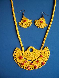 "Crocheted Golden Yellow Necklace and Earrings Set with Coral Beads  You are sure to get compliments with this necklace and earrings embellished with genuine coral beads. The necklace has matching crocheted chain with nicely finished ends.  The earrings are on copper ear wires. Earrings are approx. 2 1/4\" long Necklace is approx. 1 3/4\" L x 1 1/2\" W Total length is approx. 16 1/4\" long x 3/3/4\" wide" Yellow Crochet Jewelry Gift, Yellow Crochet Bohemian Jewelry, Red Bohemian Crochet Jewelry, Yellow Bohemian Crochet Jewelry, Yellow Necklace, Necklace And Earrings Set, Coral Beads, Necklace And Earrings, Golden Yellow