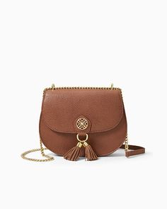 Crossbody bag with gold metal logo hardware, fringed tassels, and a gold metal chain strap. Measures 8 1/2"W x 7"H x 2"D with a 22" crossbody drop.  Shrunken Leather. Spot clean only. Imported. Complete your look with our elegant Sirena Leather Crossbody Bag. Elegant Brown Shoulder Bag With Tassels, Gold Saddle Bag With Gold-tone Hardware, Luxury Shoulder Bag With Fringe, Luxury Travel Shoulder Bag With Tassels, Elegant Gold Bag With Fringe, Chic Tassel Crossbody Shoulder Bag, Chic Crossbody Shoulder Bag With Tassels, Luxury Gold Bags With Tassels, Elegant Crossbody Bag With Tassels