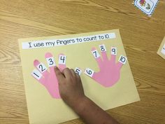 a child's hand on top of a piece of paper that says i use my fingers to count to 10