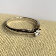 a white gold ring with a single diamond