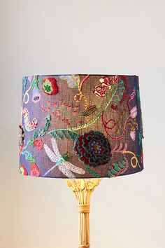 a table lamp with a colorful fabric shade on it's base and an ornate design