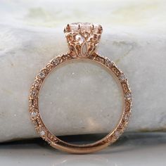 a close up view of a ring with diamonds on the inside and outside, sitting on a rock